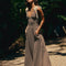 model wearing brown and white stripe maxi dress with deep v neckline and cream tie straps