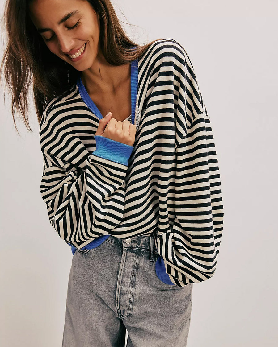 model wearing black and white horizontal stripe crewneck sweatshirt with royal blue trim