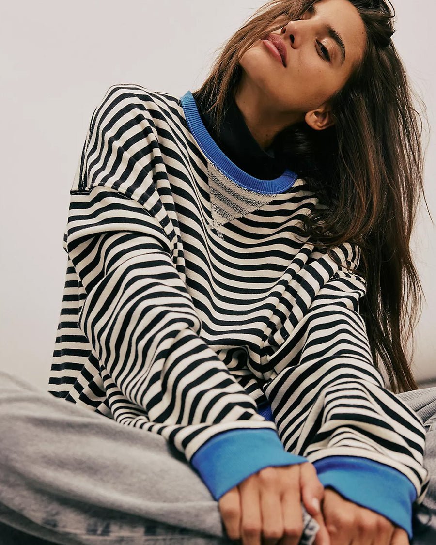 model wearing black and white horizontal stripe crewneck sweatshirt with royal blue trim