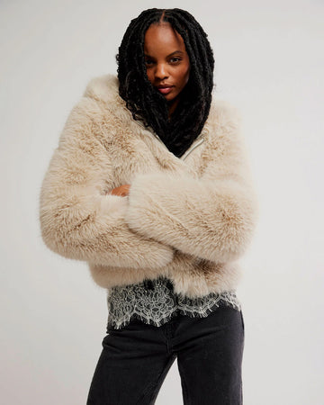 model wearing ivory cropped faux fur jacket with hood