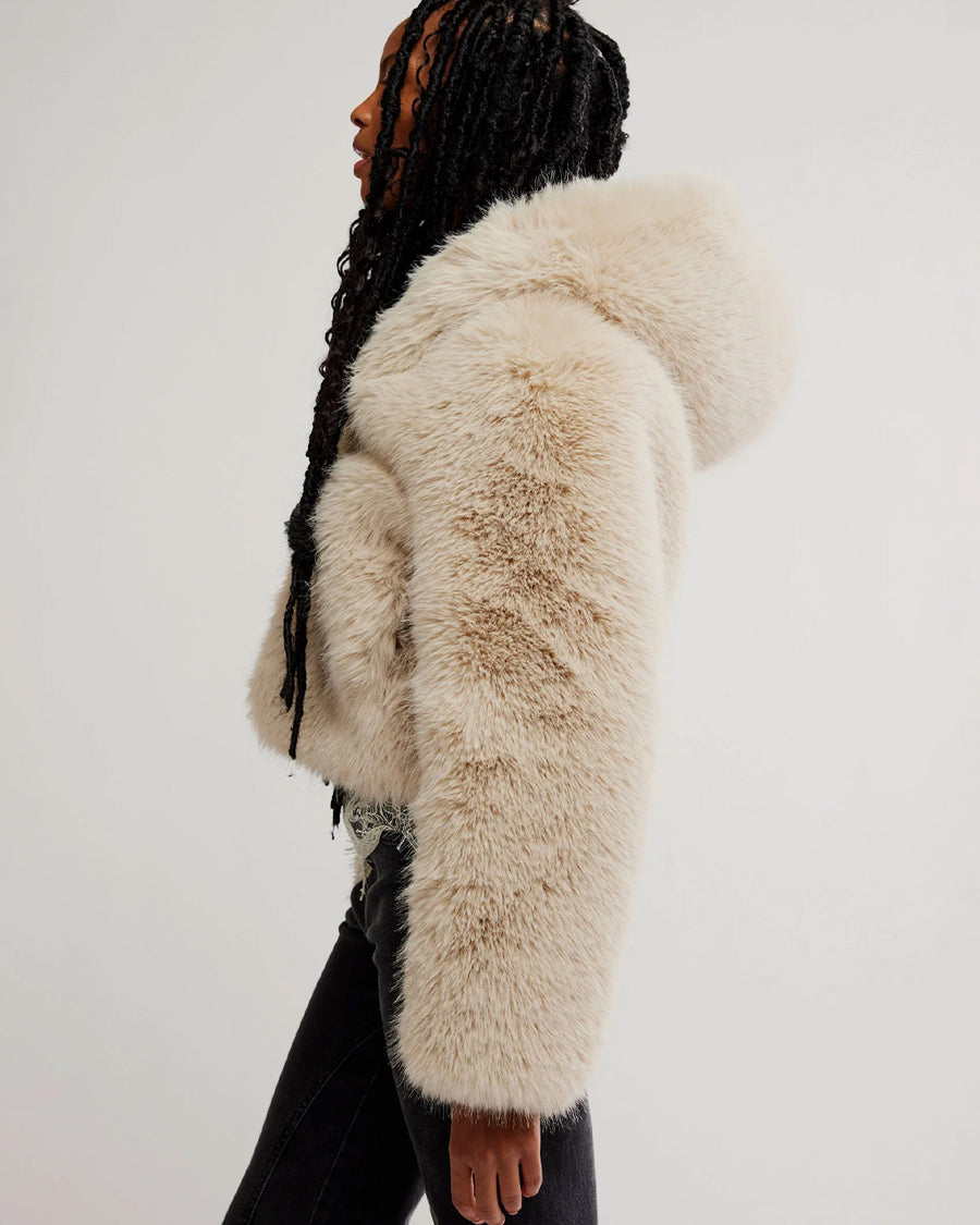 side view of model wearing ivory cropped faux fur jacket with hood