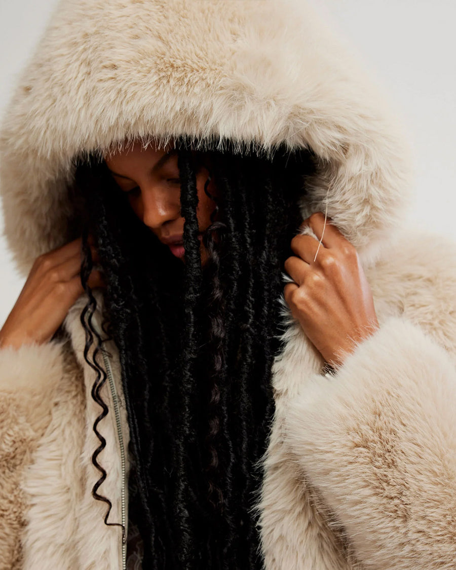 up close of model wearing ivory cropped faux fur jacket with hood