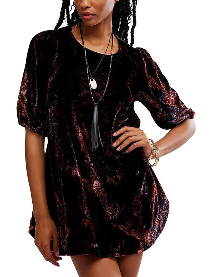 model wearing black velvet tunic with red and burgundy floral print and short sleeve puff sleeves