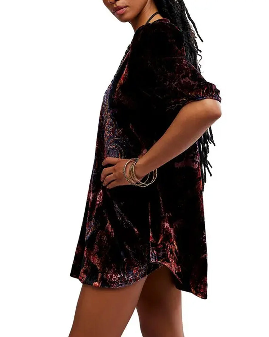 side view of model wearing black velvet tunic with red and burgundy floral print and short sleeve puff sleeves