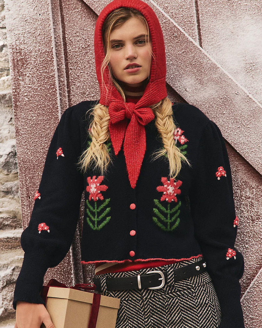 model wearing black cropped cardigan with red folk floral print on the front and sleeves
