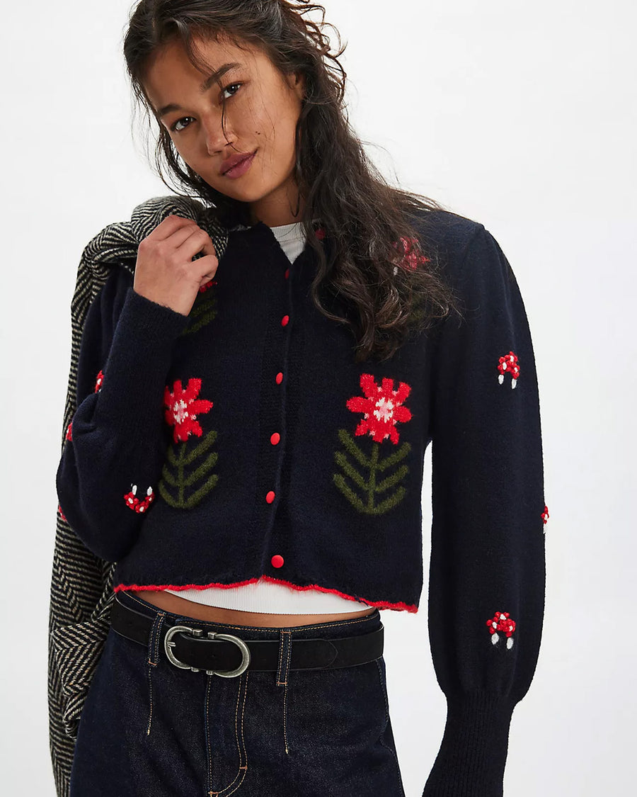 model wearing black cropped cardigan with red folk floral print on the front and sleeves
