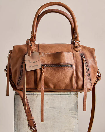 brown leather barrel purse with long strap zipper pulls and various zipper compartments