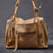light tan leather purse with several zippered pockets, double handles and crossbody strap