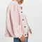 side view of model wearing baby pink cardigan with extended placket, patch pockets and large button front