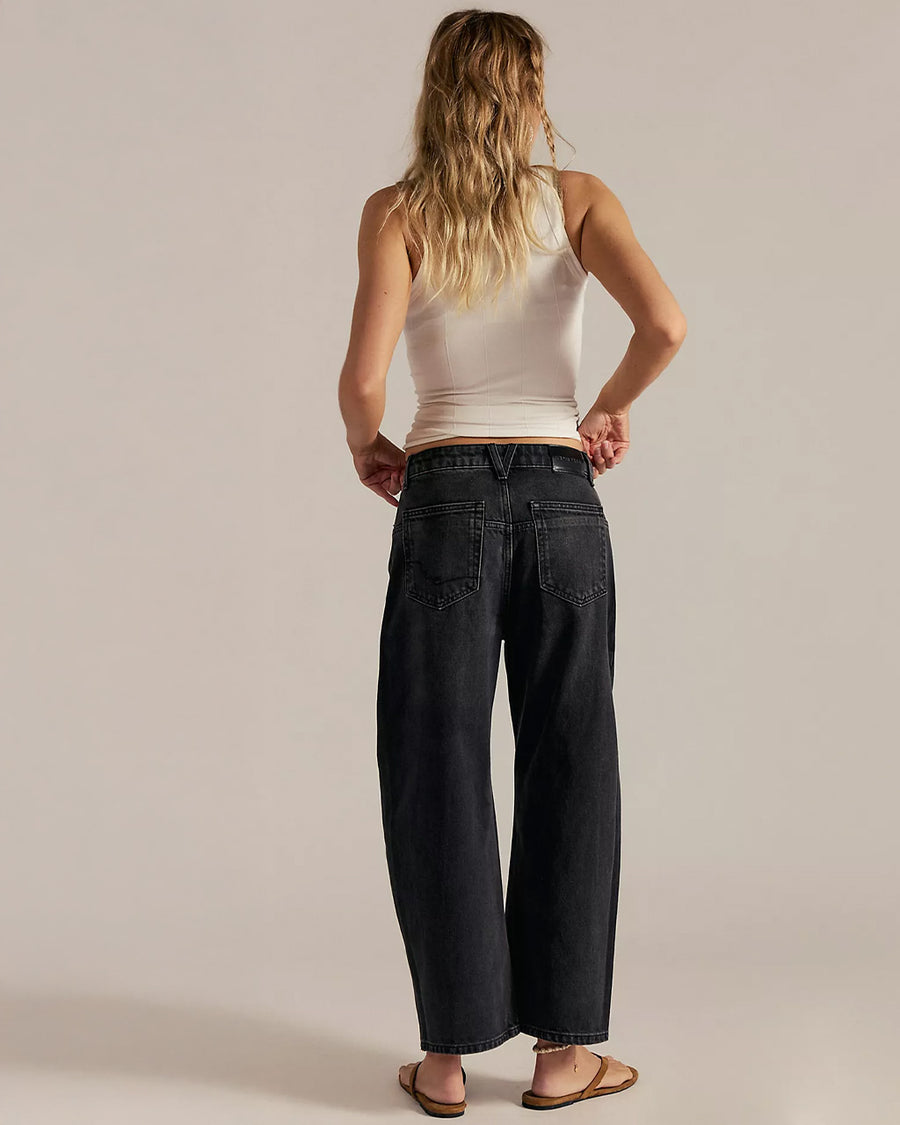 back view of model wearing washed black relaxed fit low rise denim