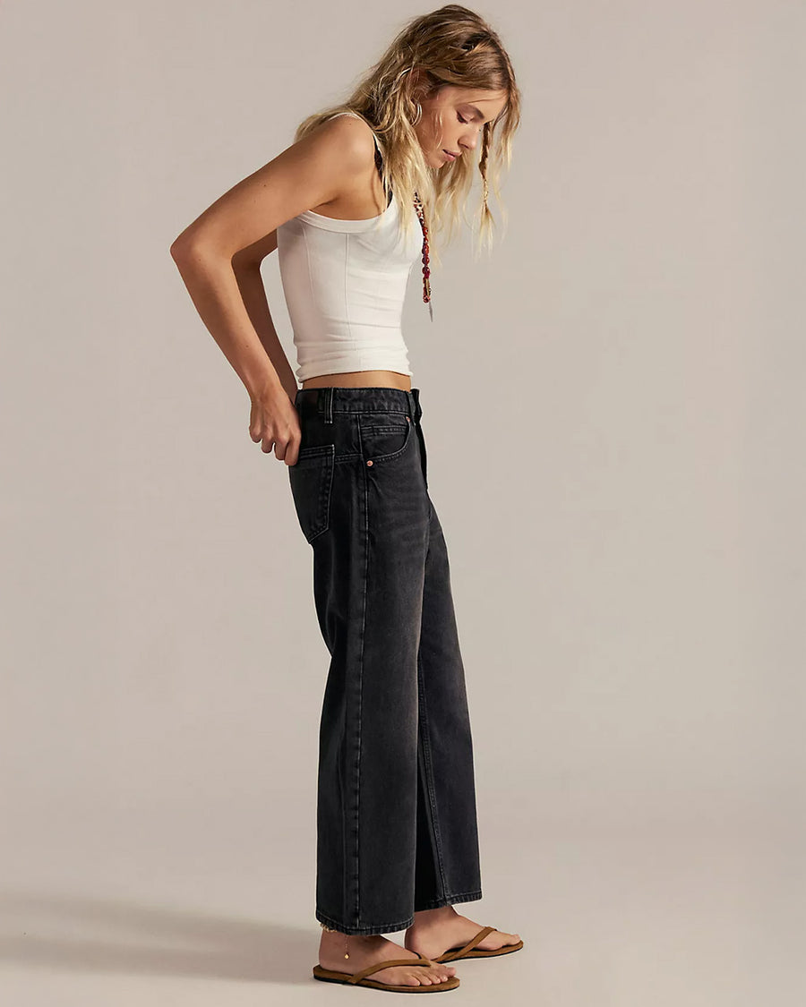 side view of model wearing washed black relaxed fit low rise denim