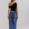 back view of model wearing light indigo pull on jeans with elastic tie waist and patch front pockets