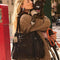 model carrying black leather purse with several zippered pockets, double handles and crossbody strap