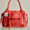 rusty red leather purse with several zippered pockets, double handles and crossbody strap