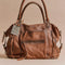 dark brown leather tote bag with several pockets and zippers