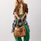 model holding dark brown leather tote bag with several pockets and zippers