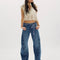model wearing low rise dark denim barrel jeans