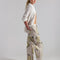 side view of model wearing tan barrel jeans with all over painted banana print