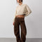 model wearing dark brown vegan suede pants and oatmeal sweater