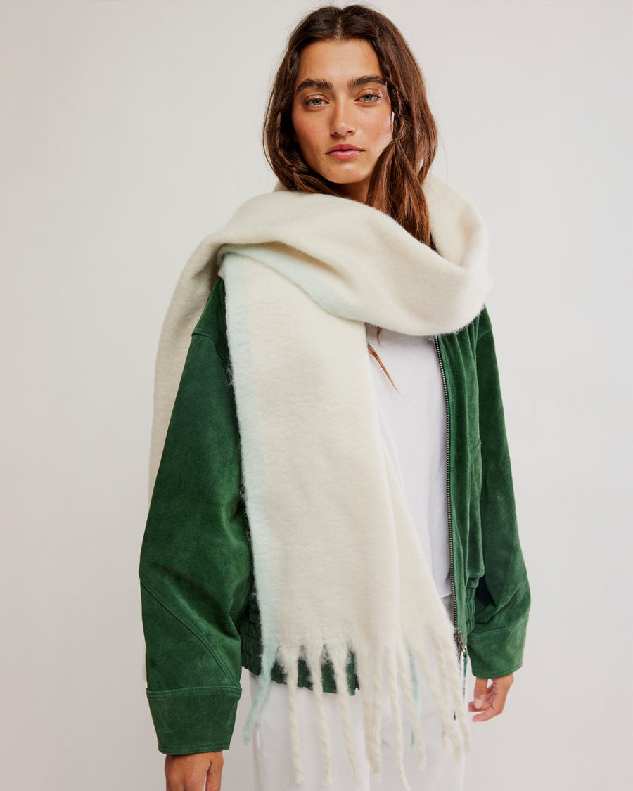 model wearing thick subtle blue and white oversized scarf with white fringe