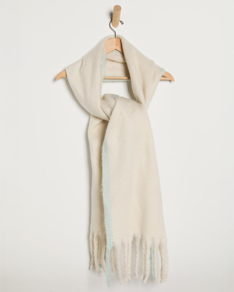 thick subtle blue and white oversized scarf with white fringe on a hook