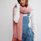 model wearing thick pink and white oversized scarf with red fringe