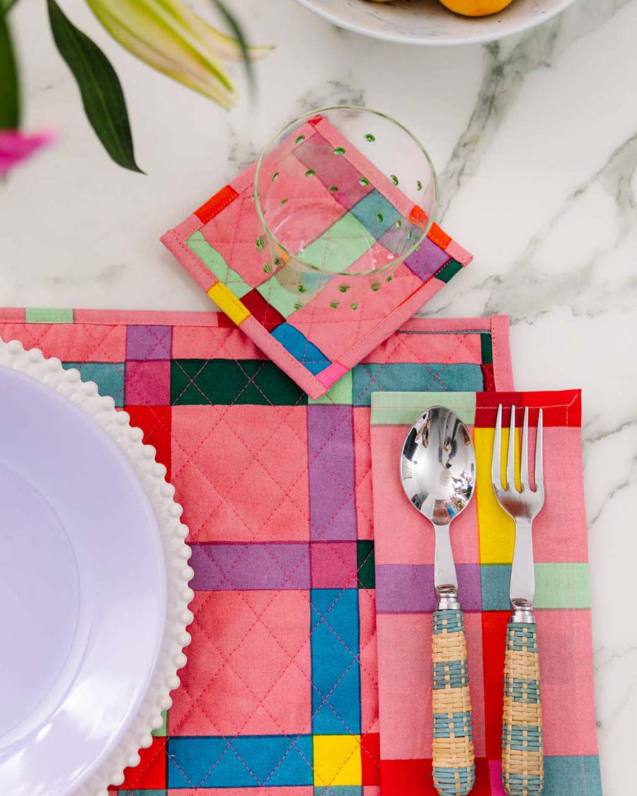 pink tea towel with colorful picnic plaid print on table