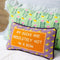 purple throw pillow with duck border and 'my ducks are absolutely not in a row' across the front on a bed