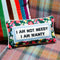 floral rectangular throw pillow with 'i am not needy, i am wanty' across the front on couch