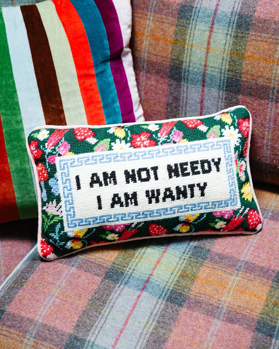floral rectangular throw pillow with 'i am not needy, i am wanty' across the front on couch