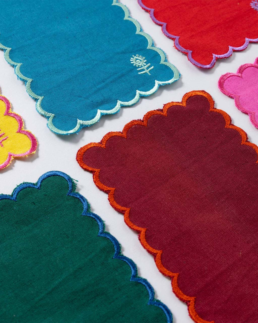 up close of set of 6 rainbow linen cocktail napkins with scalloped edges