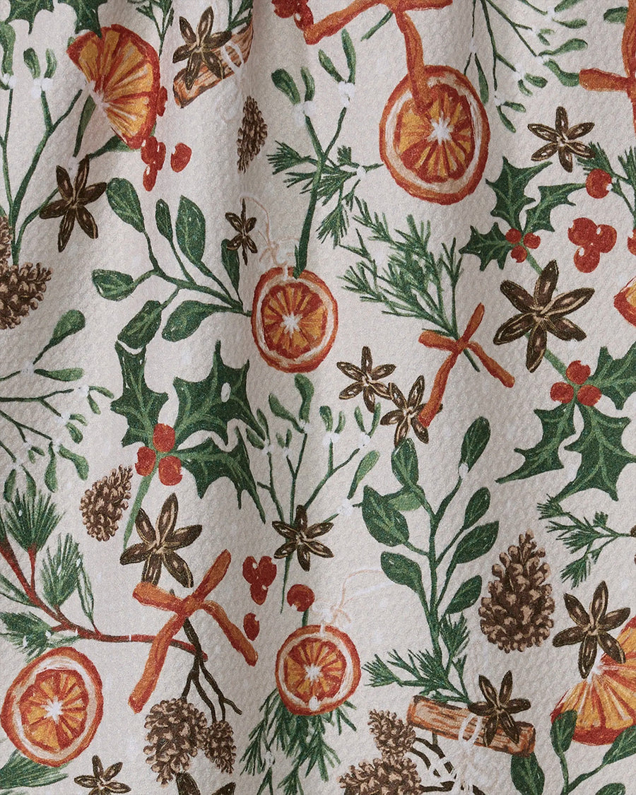up close of white tea towel with dried orange, cinnamon, and cranberry print