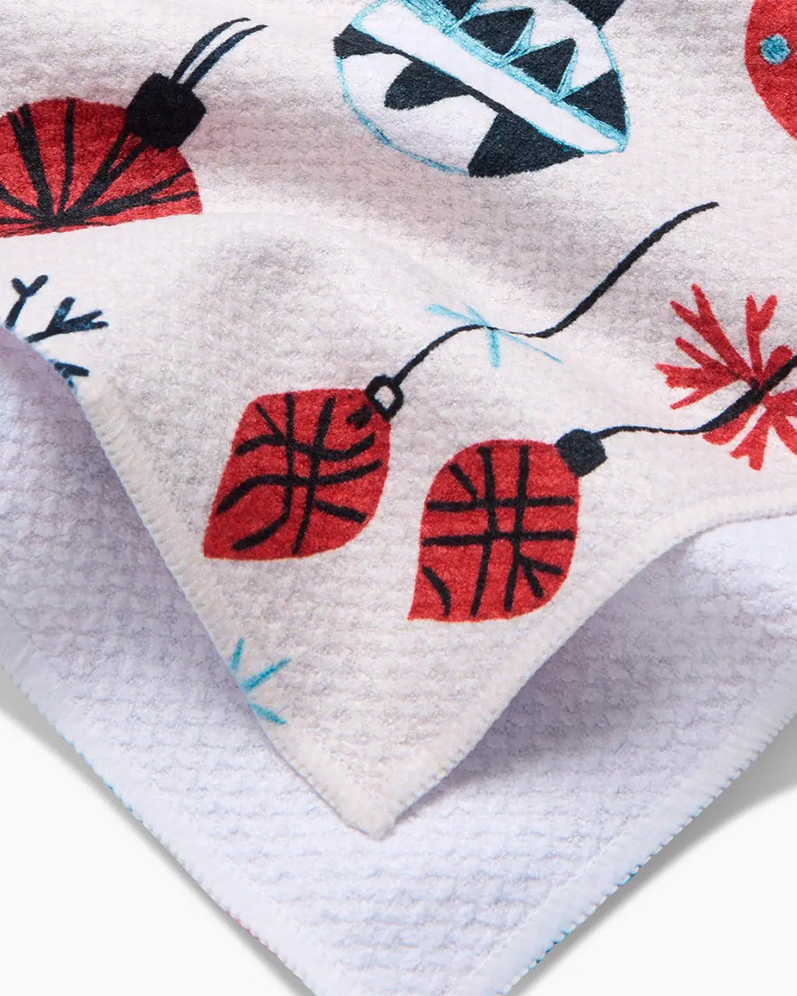 up close of cream tea towel with colorful ornament and tree print
