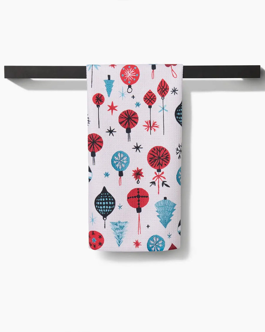 cream tea towel with colorful ornament and tree print on a towel rack