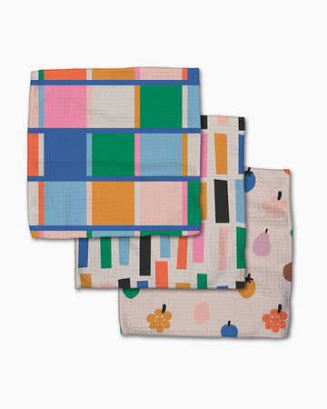 set of three dishcloths: colorful checkered, white with colorful rectangles, and tan with colorful fruits