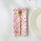 set of 6 white napkins with red holiday doodle print with a gold fork on it