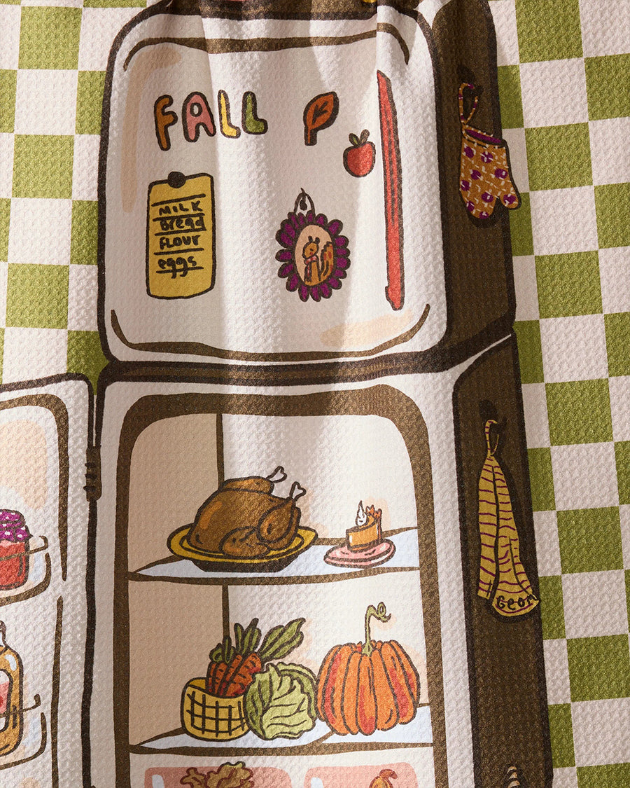 up close of green and white plaid tea towel with a fridge full of fall foods