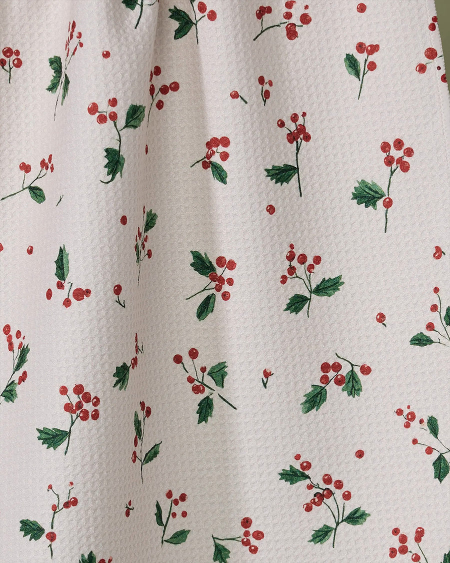 up close of white tea towel with dainty holly sprig print