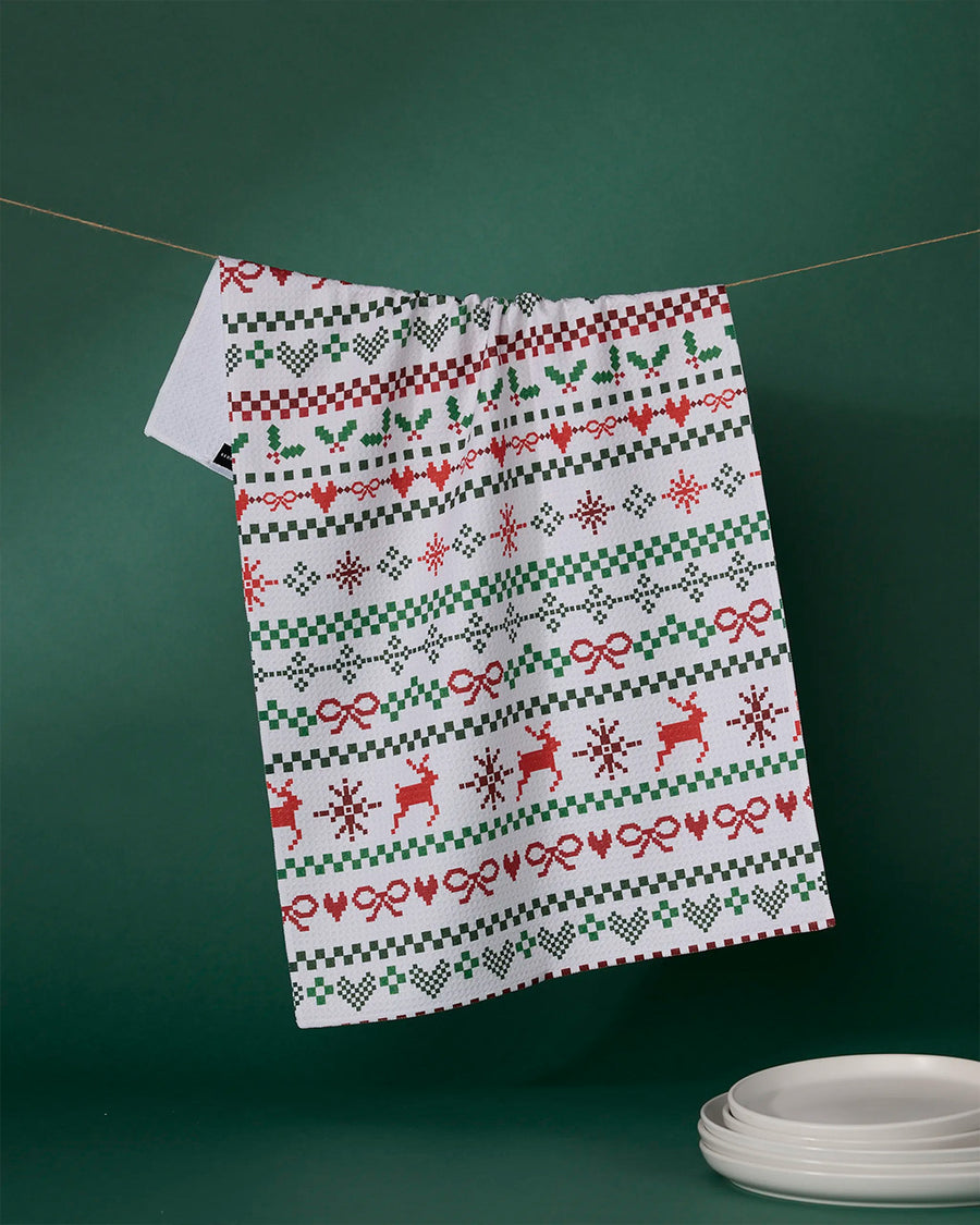 white tea towel with green and red holiday sweater print