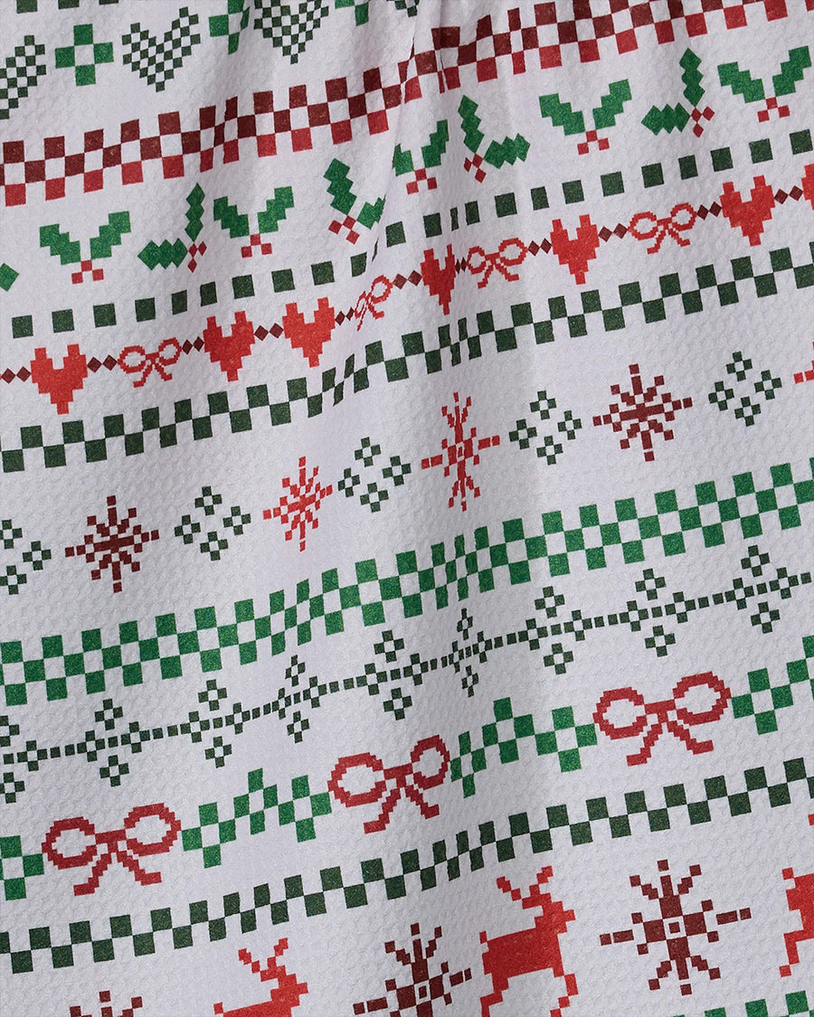 up close of white tea towel with green and red holiday sweater print