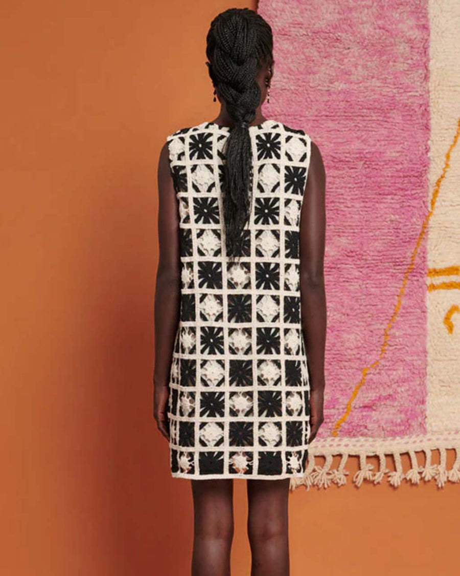 back view of model wearing white and black crochet granny square mini dress