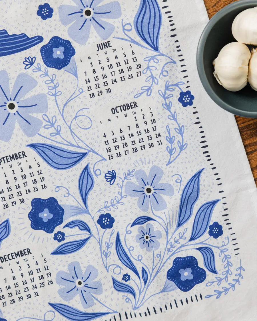 up close of white tea towel with blue sparrow birds and 2026 'calendar' by month