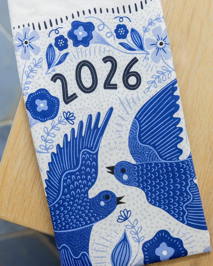 front view of white tea towel with blue sparrow birds and 2026 'calendar' by month