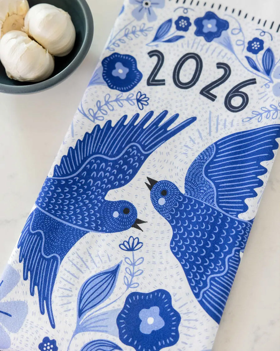 folded white tea towel with blue sparrow birds and 2026 'calendar' by month