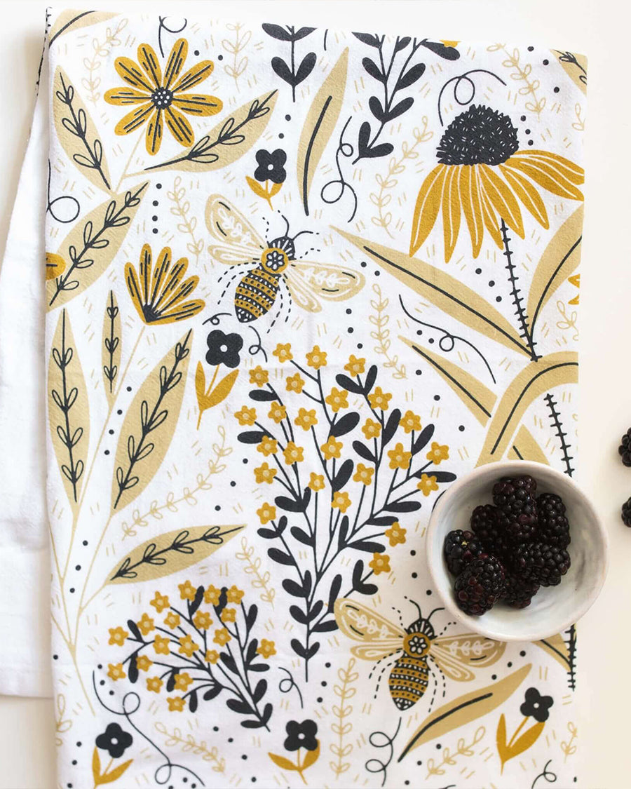 up close of white tea towel with goldenrod floral and bee print