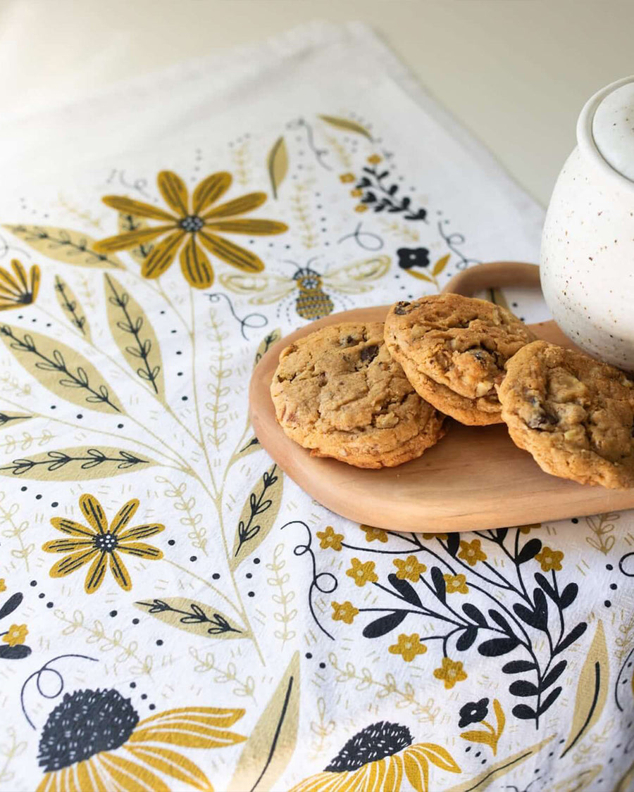white tea towel with goldenrod floral and bee print with cookies on them