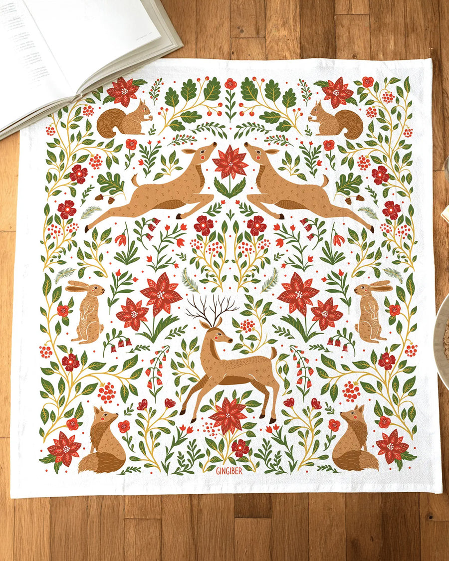 white tea towel with all over poinsettia, deer, rabbit, and fox print