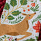 up close of the deer face on white tea towel with all over poinsettia, deer, rabbit, and fox print