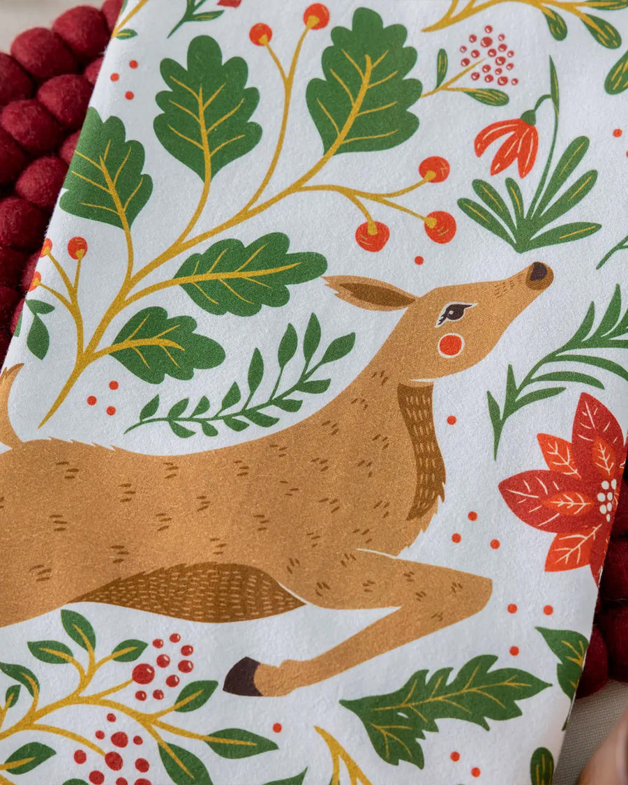 up close of the deer face on white tea towel with all over poinsettia, deer, rabbit, and fox print