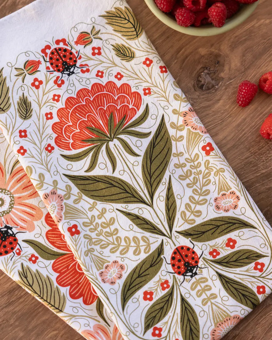 side view of ladybug and red floral abstract tea towel
